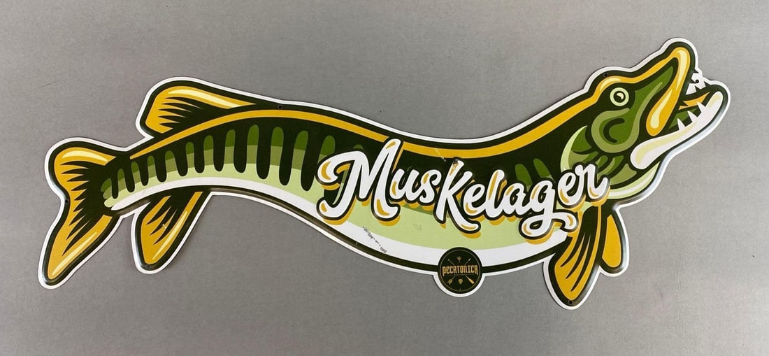 Muskelager Metal Advertising Beer Sign: Measures 22 3/4 x 8 inches.