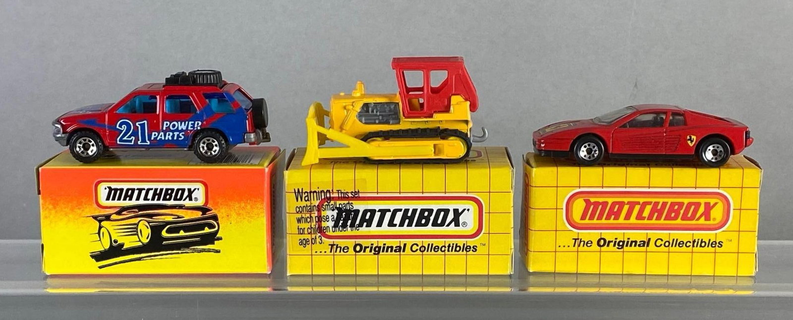 Group of 3 Matchbox Die-Cast Vehicles: With boxes, Includes No. 24 Ferrari F40, No. 56 Isuzu Rodeo, and No. 64 Bulldozer.