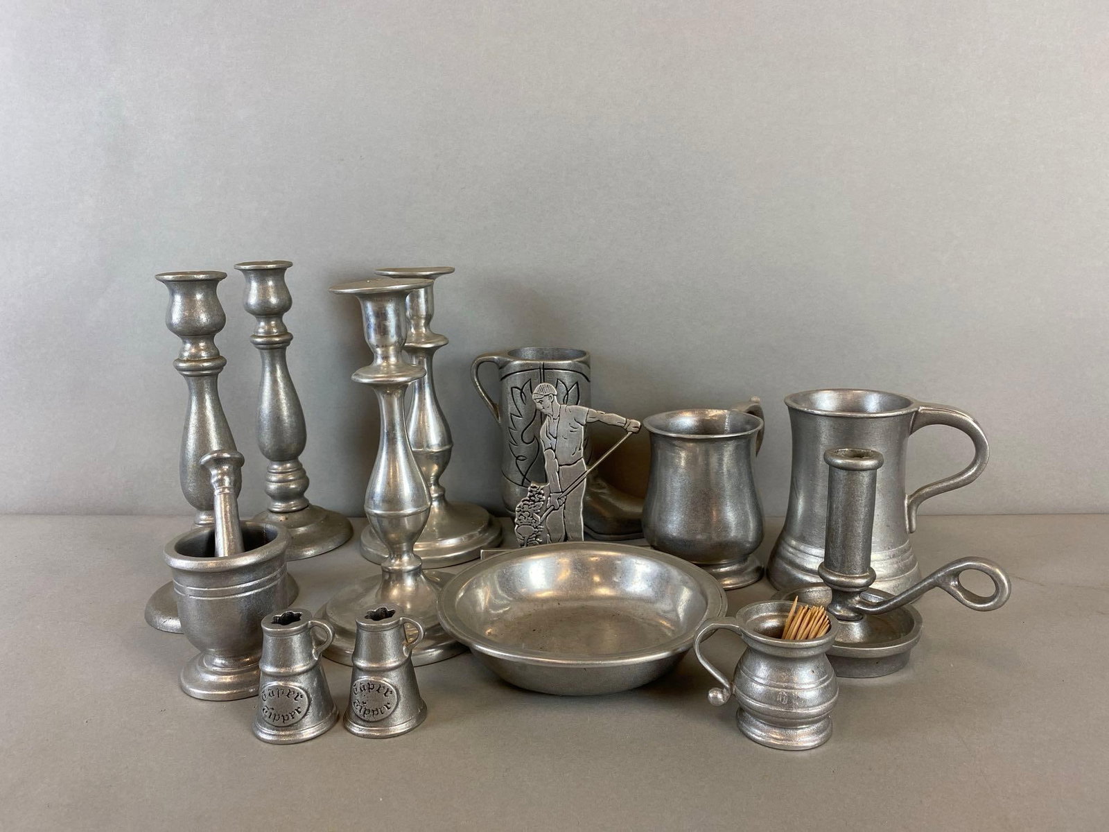 Group of Assorted Pewter Items: Brands like Carson, Wilson, Sexton. Includes Candle holders, mugs, Taper tipper and more. Largest item measures 9 x 4 3/4 x 4 3/4 inches.