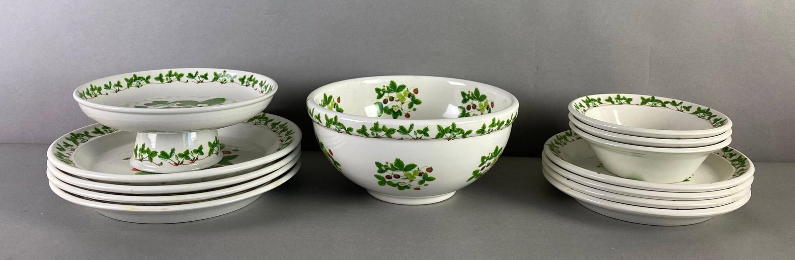 Group of 13 Portmeirion Summer Strawberry Kitchenware: made in England, includes compote, 4 dinner plates, 1 salad bowl, 3 bowls and 4 salad plates, largest plates measures 10 inches in diameter