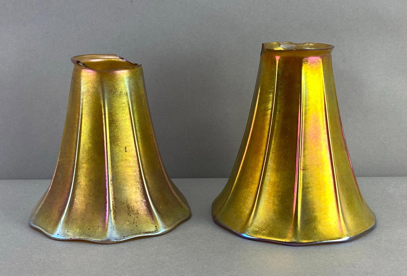 Group of 2 Antique Gold Favrile Ribbed Glass Lamp Shades: Major chips missing from fittings, largest measures 5 1/2 x 5 x 5 inches with a 2 inch fitting