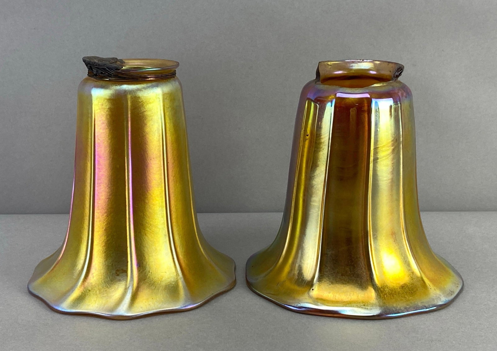 Group of 2 Antique Gold Favrile Ribbed Glass Lamp Shades: Large chips and repairs along fittings, largest measures 5 1/2 x 5 x 5 inches with a 2 inch fitting