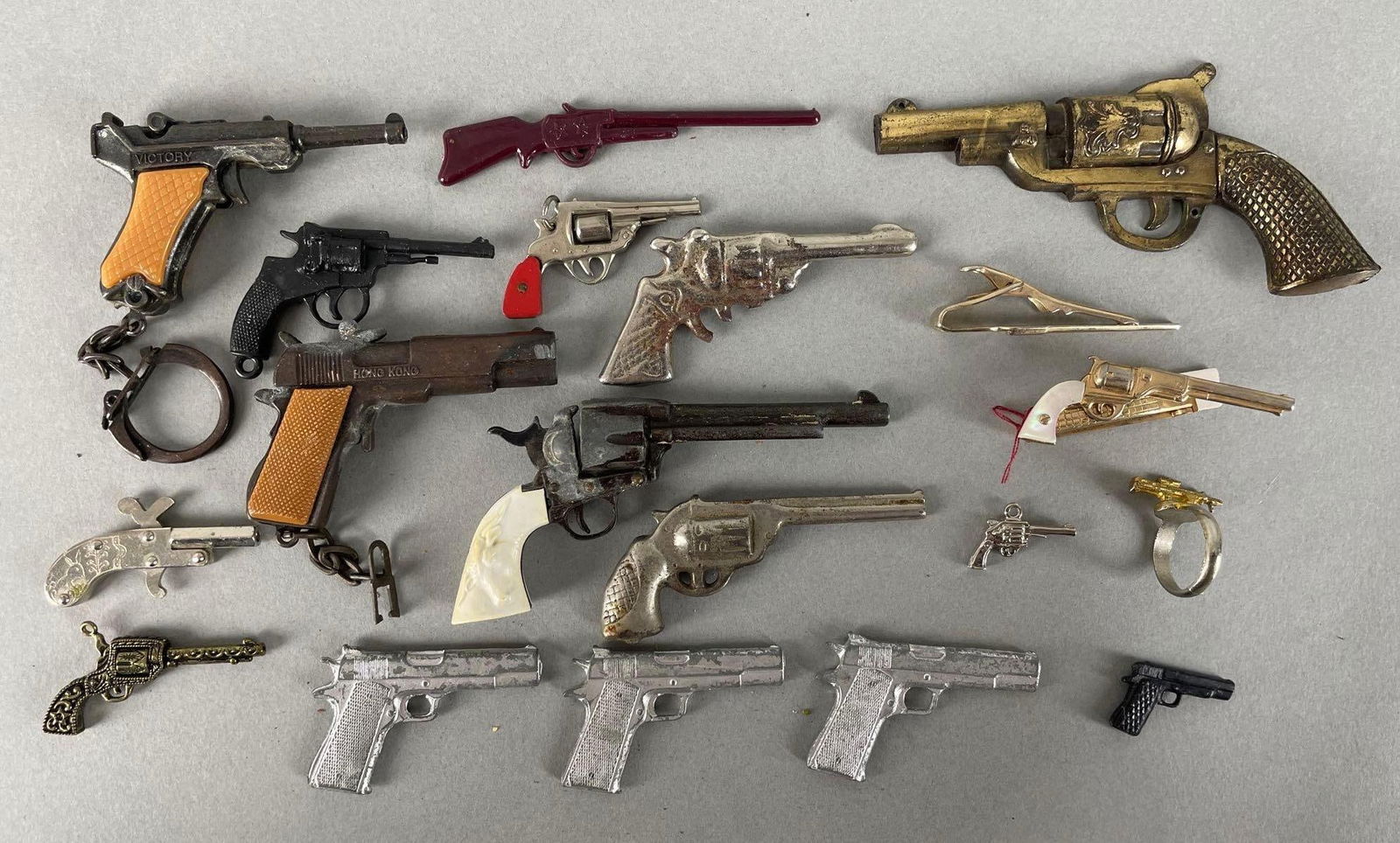 Group of Miniature Guns: Includes hair clips, ring, G.I. Joe rifle, and more. Largest measures 3 1/2 x 2 inches