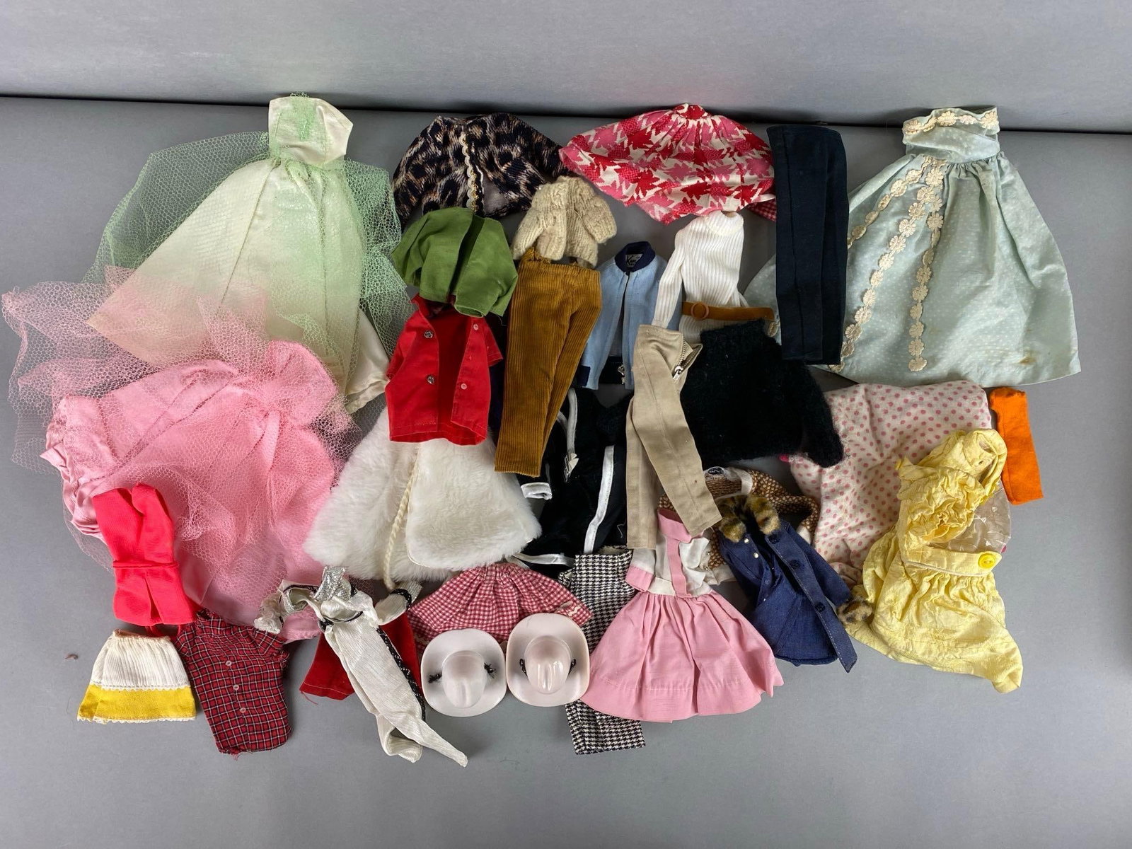 Group of Vintage Doll Clothing: Includes Green & pink netted dresses, leopard jackets, fur cape and more. Largest item measures 9 x 9 inches