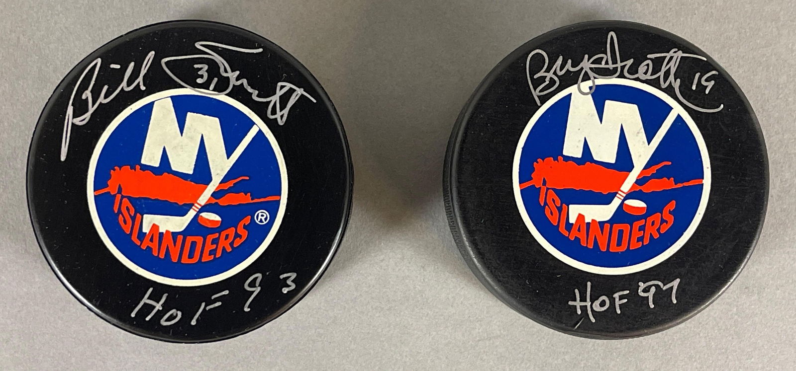 Brian Trottier and Bill Smith Signed Official NHL Islanders Pucks with Inscriptions: Brian Trottier #19 HOF97, and Bill Smith #31 HOF93, We guarantee this to pass a 3rd party authentication, 2 - Cases included