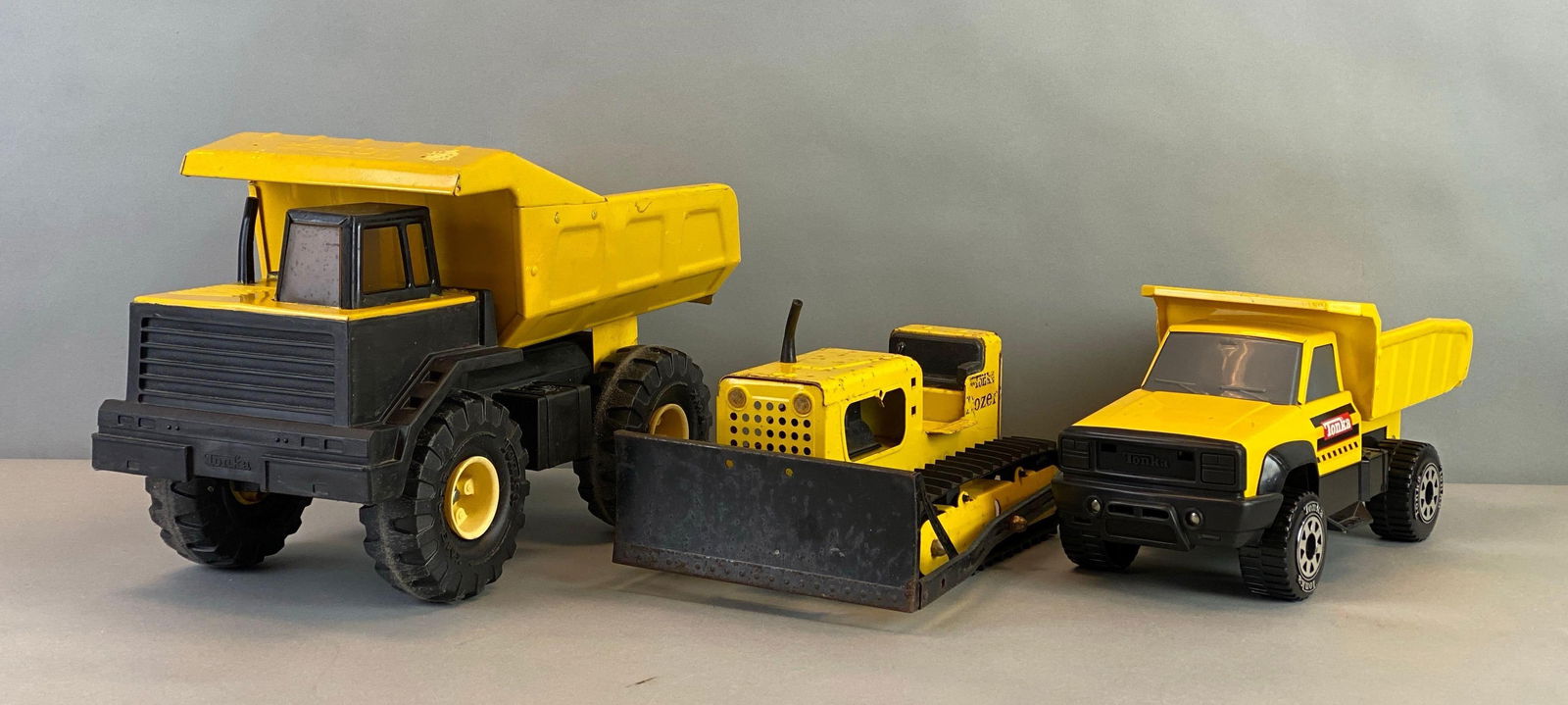 Group of 3 Tonka Pressed Steel Heavy Equipment Vehicles: Includes dump truck, dozer and Pickup Dump truck, largest measures 10 x 17 x 8 inches