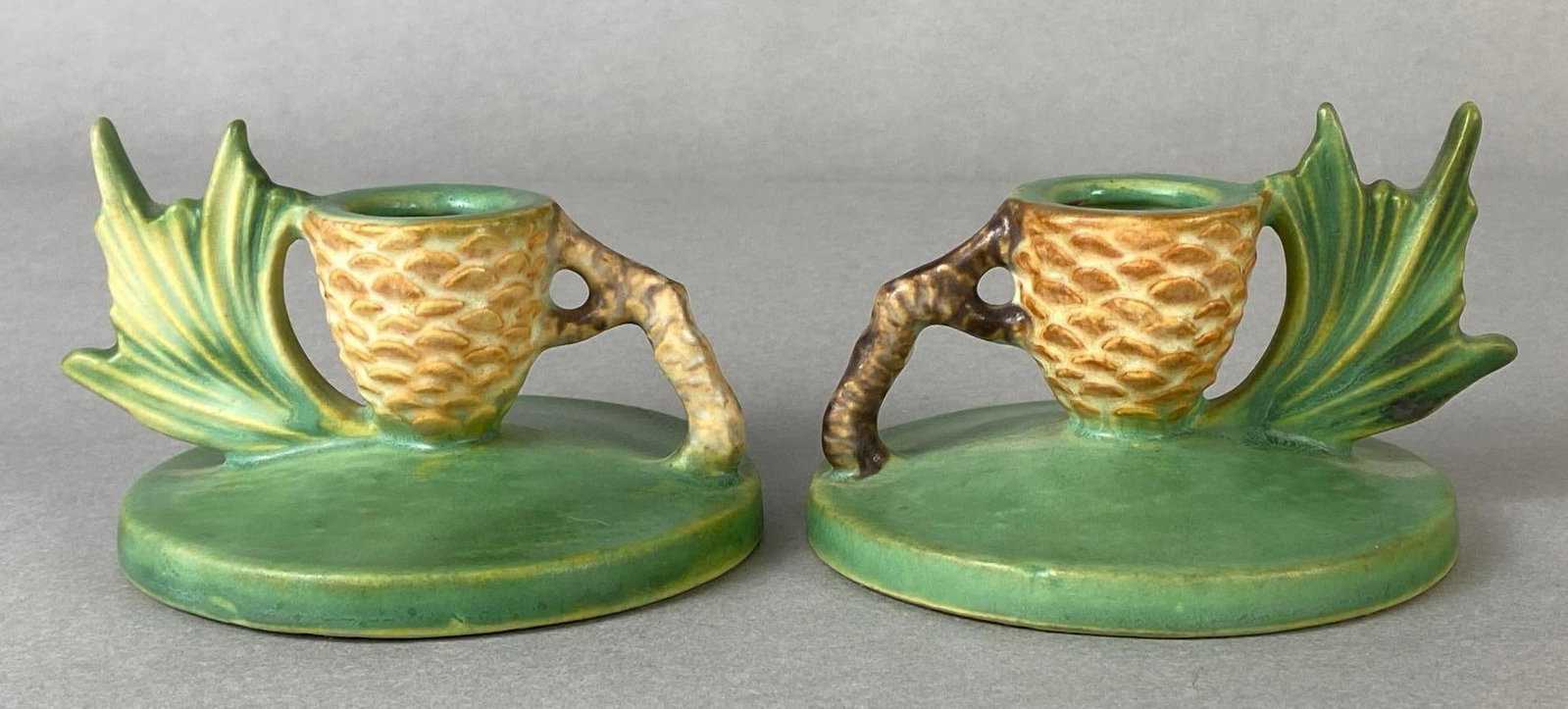 Pair of Roseville Pottery Green Pinecone Candleholders: Pattern No. 1123, Both measure 2 3/4 x 4 1/4 x 4 inches.