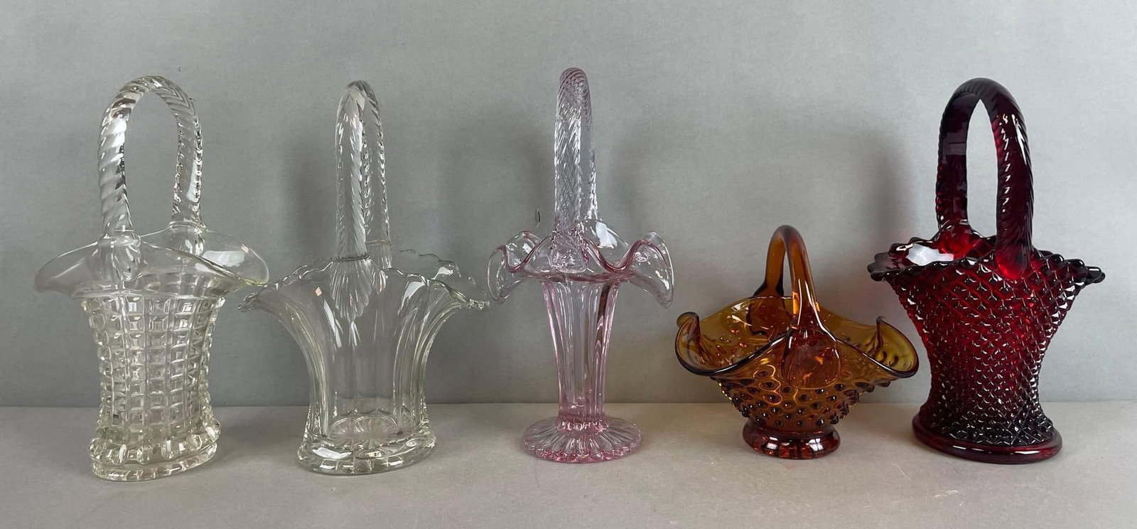 Group of Fenton Glass Baskets: Includes Amber hobnail, cranberry, clear. Largest measures 9 x 6 x 3 3/4 inches