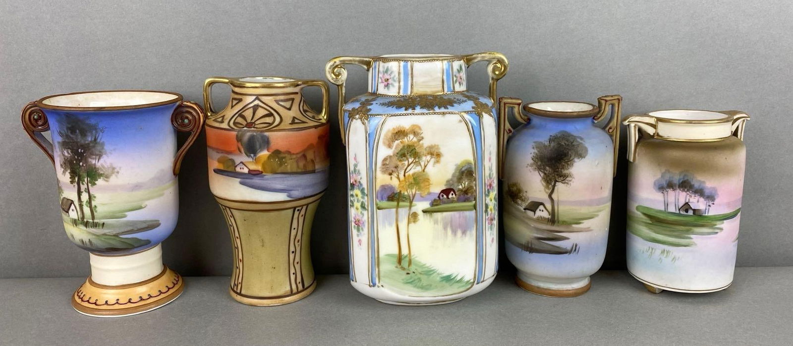Group of 5 Nippon Hand Painted Porcelain Vases: Vases depict scenic houses on water. Some handles show wear. Largest items measures 5 1/5 x 4 1/4 x 2 3/4 inches.