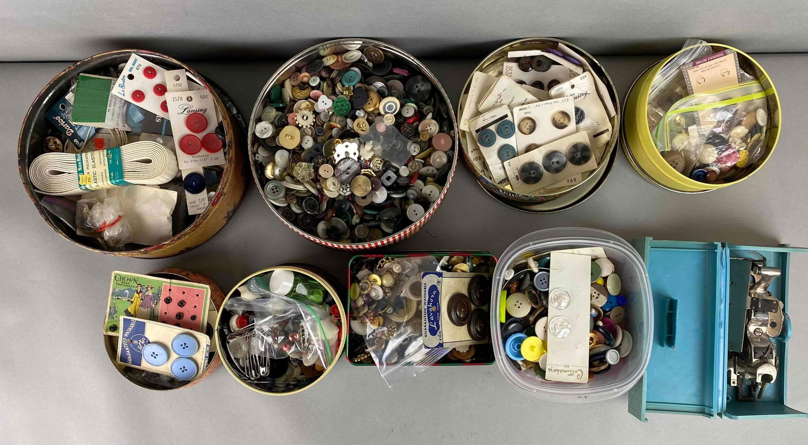 Group of Vintage Buttons and More: Includes famous buttonhole worker, tins, safety pins and more. Largest tin measures 3 1/2 x 8 1/4 inches.