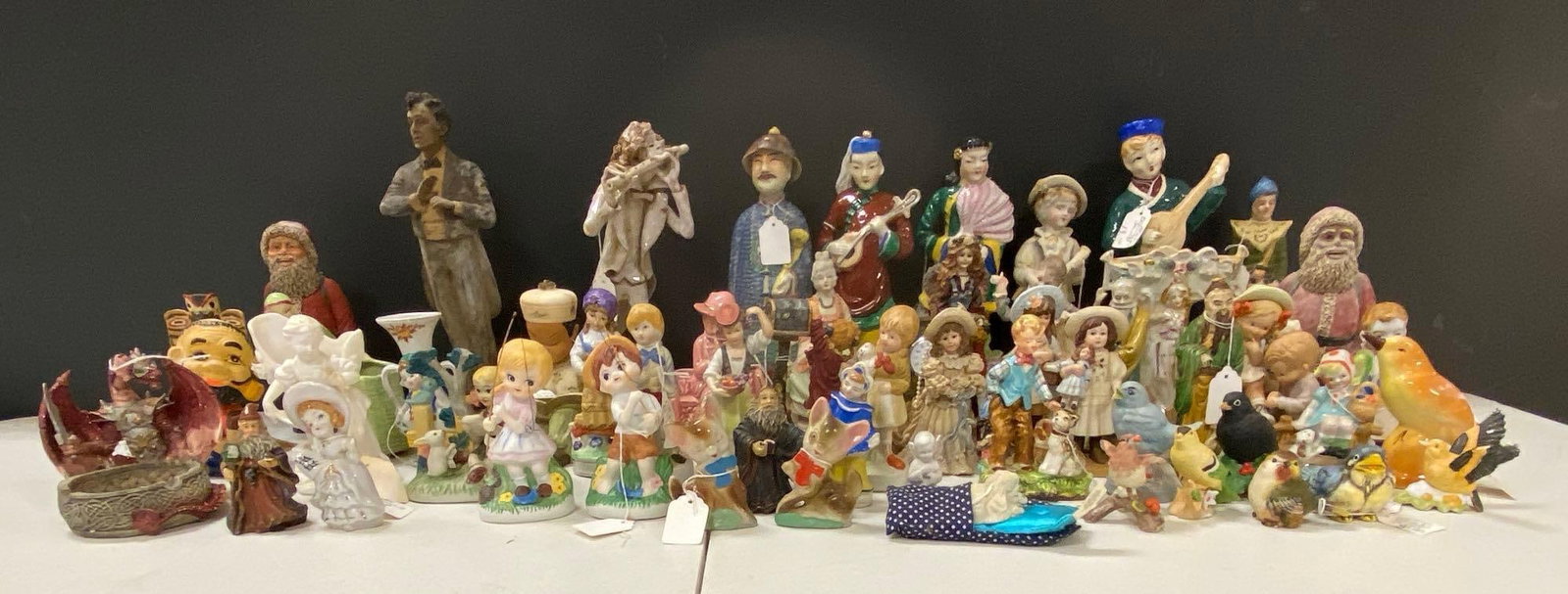 Group of Ceramic and Resin Decorative Figurines: Includes Santa Claus, various birds, Children and more. Largest item measures 12 x 6 x 6 inches.