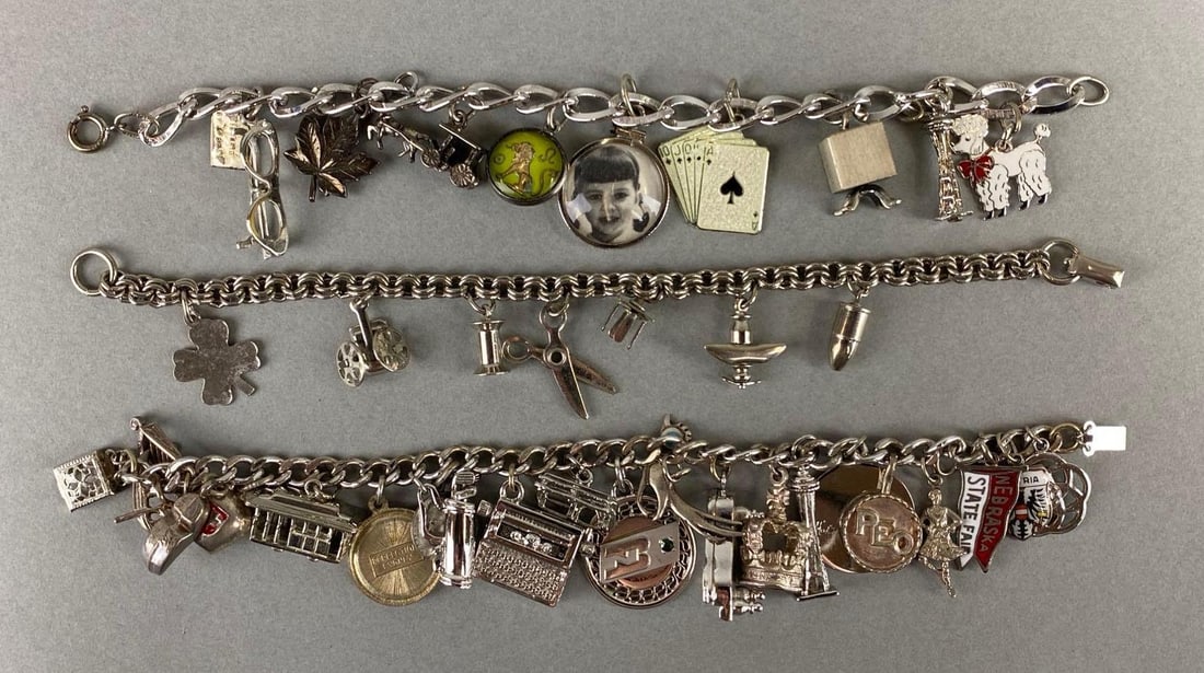 Group of Sterling Silver Charm Bracelets: Sterling silver. Weighs 94.3 grams. Includes scissors, trolley cart, poodle and more. Bracelet measures 6 3/4 inches.