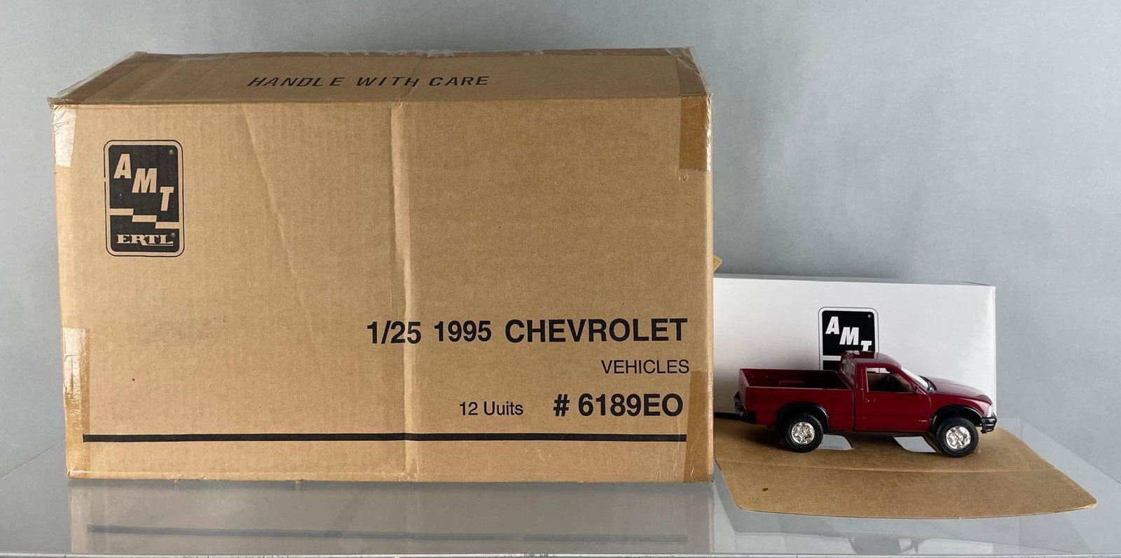 Box of 12 AMT Ertl 1995 Chevy S10 Dealership Promo Trucks: Cherry red metallic, 1/25 scale, new in original boxes
