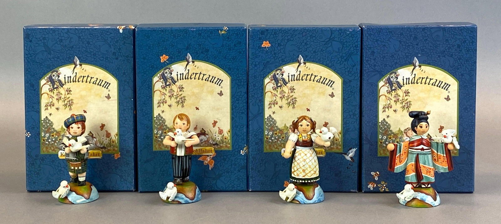 Group of 4 German Kindertraum Limited Edition Wood Dove Children Figurines: all in original boxes with COAs, features German, Scottish and Japanese children, largest measures 2 1/2 x 2 x 2 inches