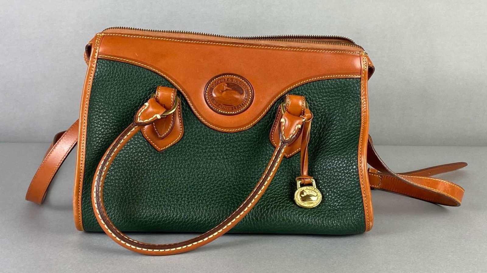 Dooney and Bourke Green and Brown Leather Purse: With dust bag, Purse body measures 8 x 11 1/4 x 5 3/4 inches.