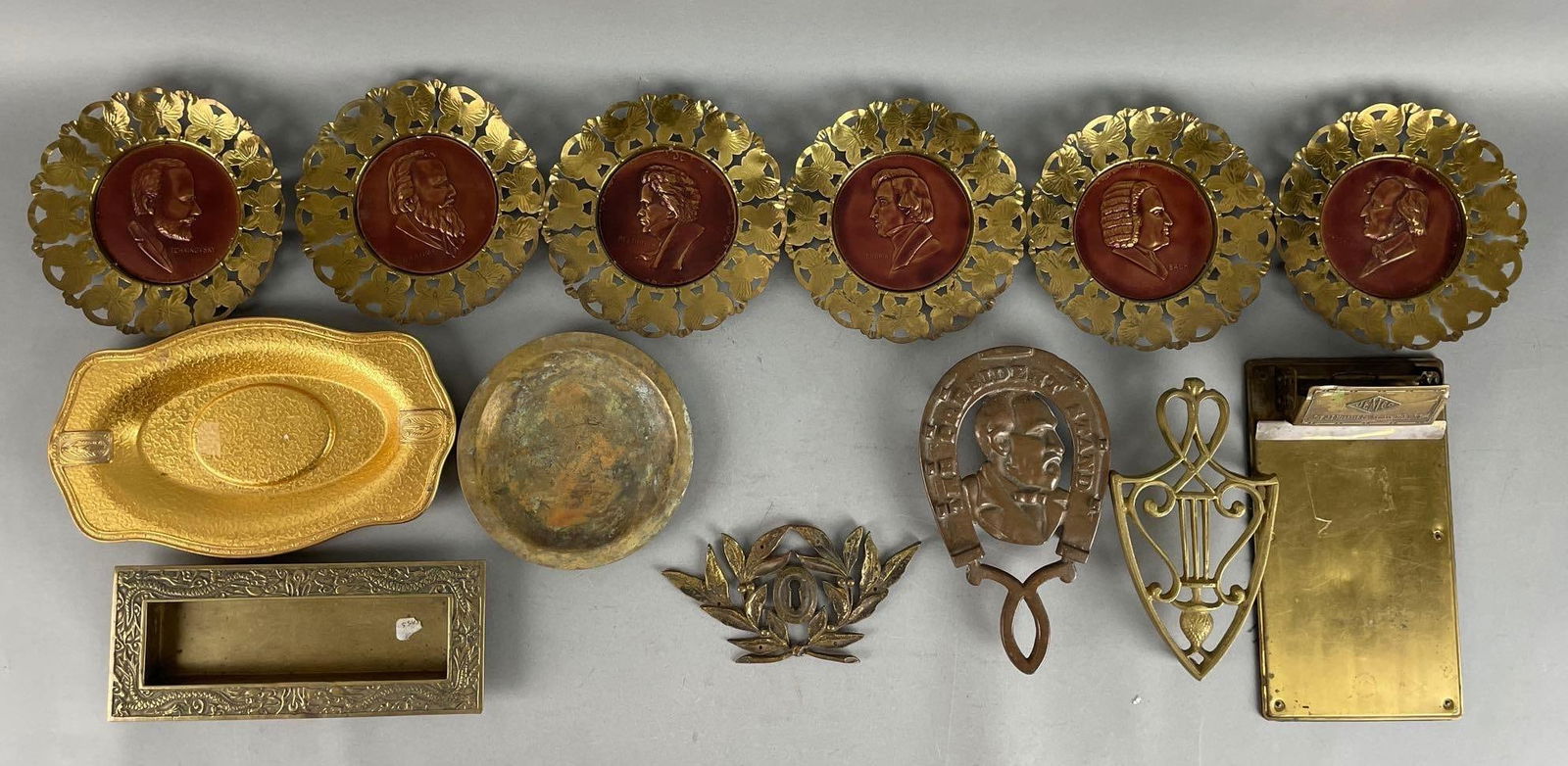 Group of Assorted Vintage Brass and Metal Items: Includes composer wall plaques jemco brass clipboard, president stand trivet, and more. Largest tray measures 5 3/4 x 9 1/2 inches