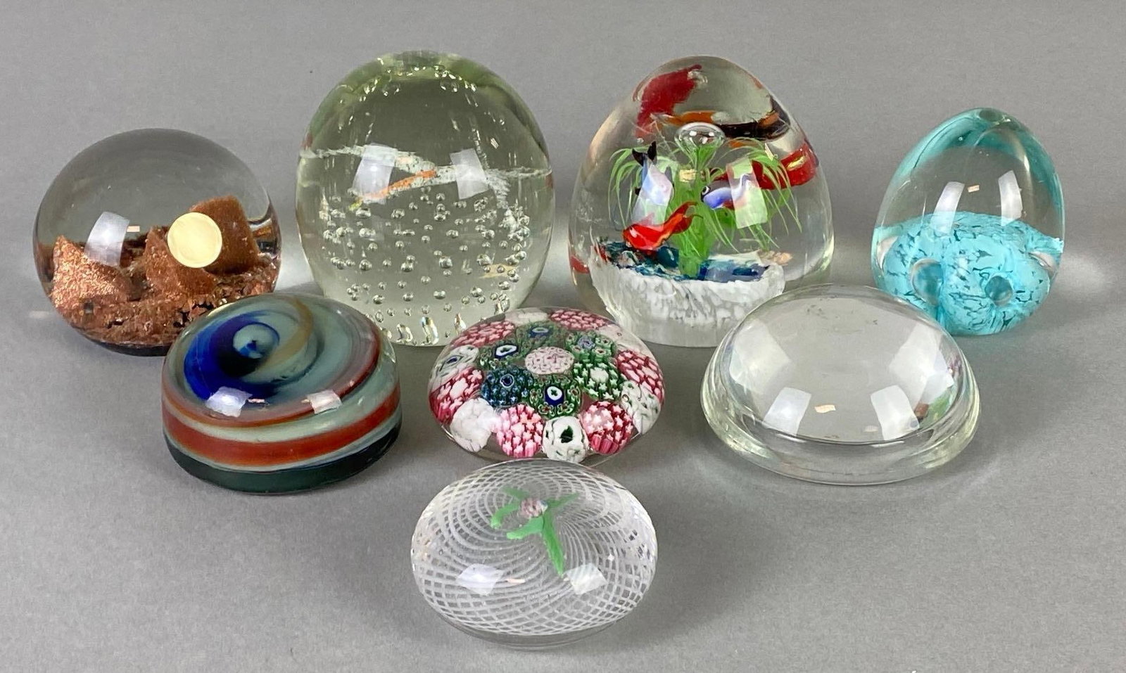 Group of Art Glass Paperweights and More: Includes fish, flying bird, abstract swirls, and more, Largest measures 3 1/2 x 3 1/4 x 3 1/4 inches.
