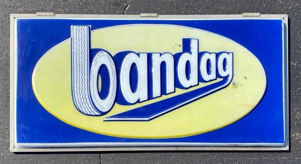 Bandag Tire Advertising Sign: NO IN HOUSE SHIPPING AVAILABLE, THIRD PARTY SHIPPING RECOMMENDED, some cracks and scuffs shown, measures 49 x 97 1/2 inches