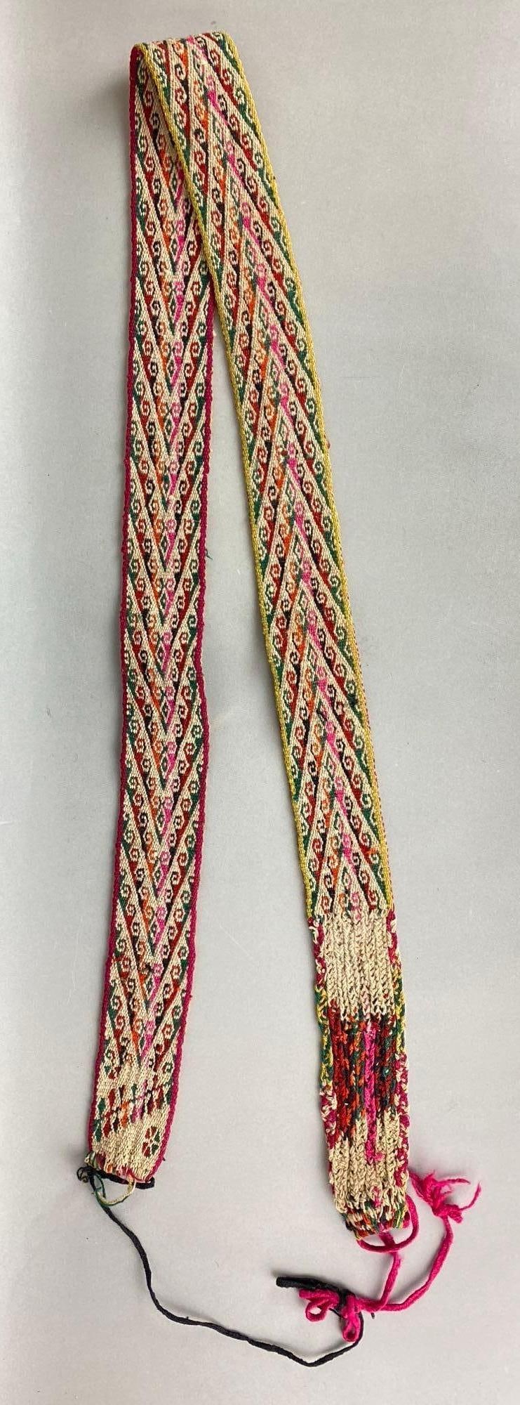 Latin American Hand Woven Chumpi Ceremonial Belt: Includes colors pink, orange, tan and more. Measures 64 x 2 1/4 inches.
