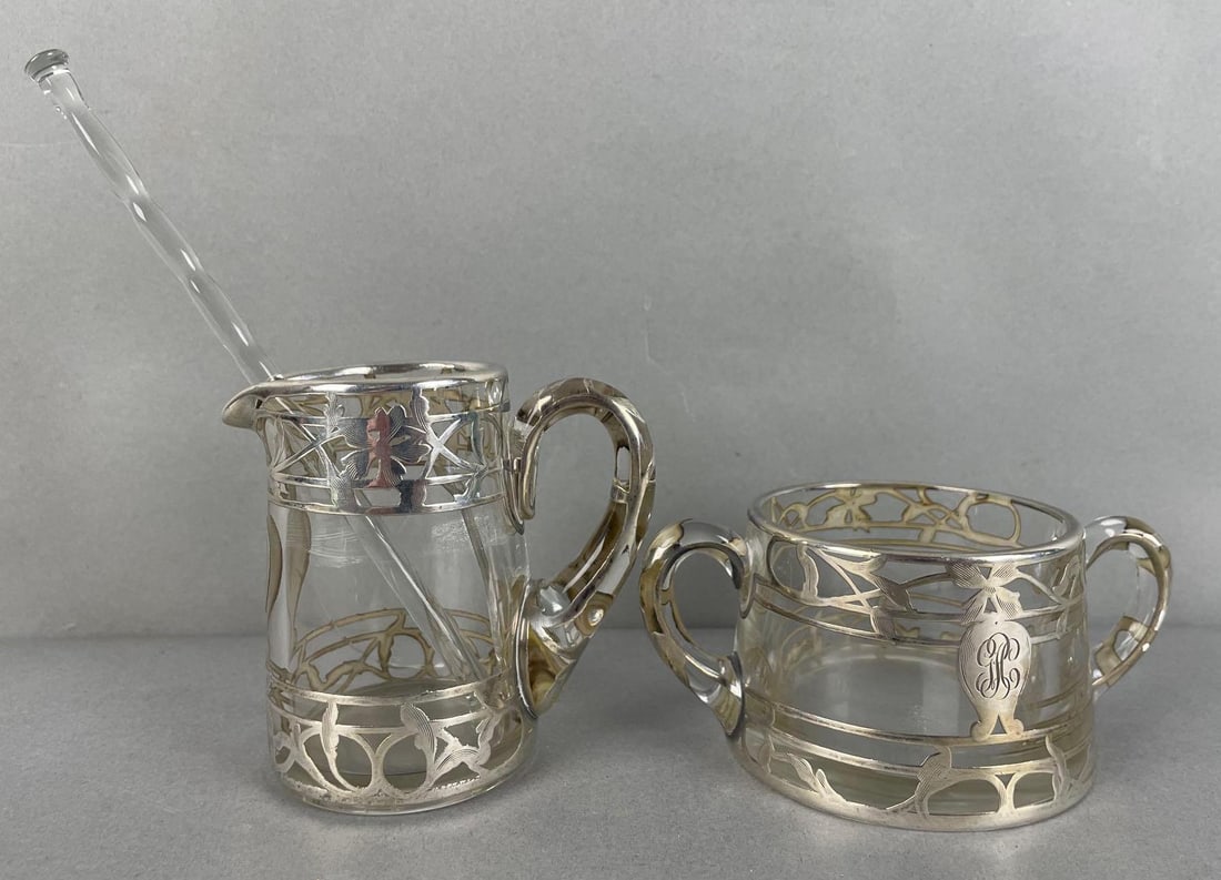 Sterling Silver Overlay Glass Creamer and Sugar Bowl: Silver deposit J352 stamped on both, creamer glass cracked. Bowl measures 2 1/4 x 5 x 3 1/4 inches