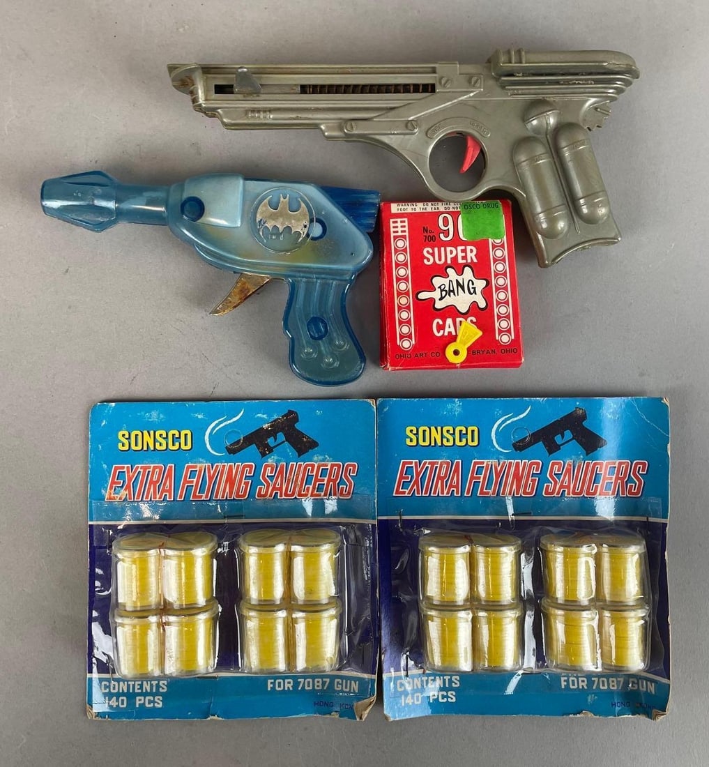 Group of Vintage Toy Guns and More: Includes super bang caps, Batman gun, sonsco packaging measures 5 1/2 x 5 1/4 inches