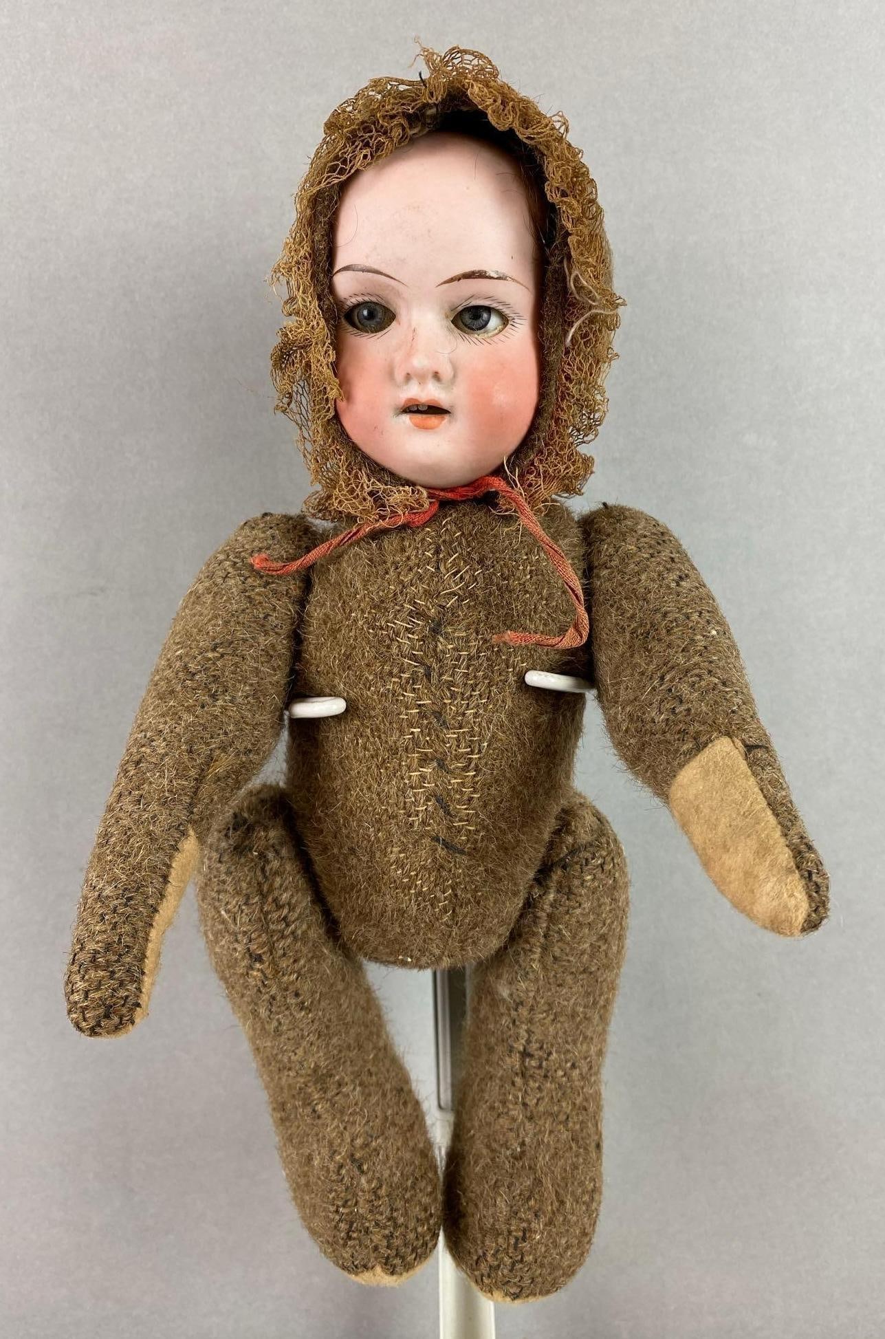 Antique Bisque Porcelain Face Doll: Articulating arms and legs. Has some missing teeth. Head marking reads made in Germany 390. Measures 11 x 5 1/2 x 3 inches.