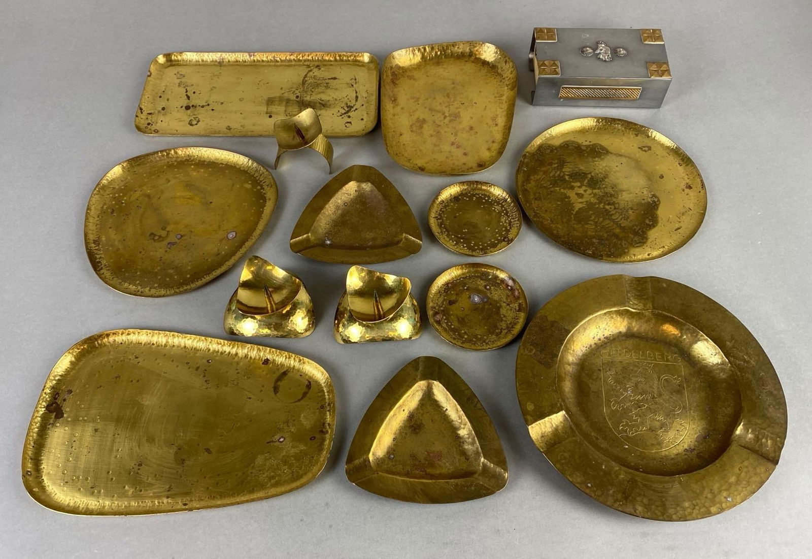 Group of Handarbeit Brass Items and More: Includes trinket trays, candleholders, anshtrays, and more, Includes Zuni style metal matchbox holder/striker, Largest measures 7 3/4 x 7 3/4 x 3/4 inches.