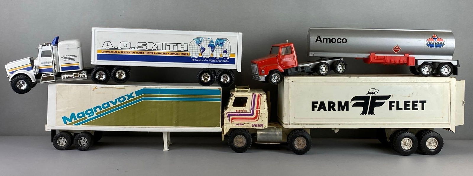 Group of 3 Pressed Steel Semi Trucks and More: Includes Plastic Magnavox trailer, Amoco Semi and Trailer, ERTL Can and more. Largest item measures 8 x 5 x 16 inches