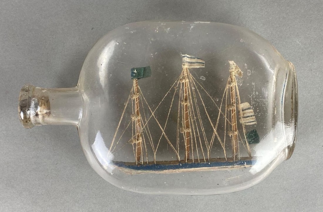 Classic Ship in a Bottle: Wood ship in clear glass bottle, Bottle measures 8 x 5 1/4 x 2 1/4 inches.