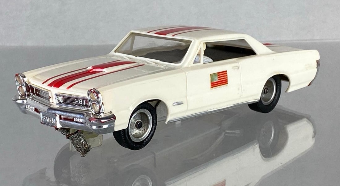 Aurora Pontiac GTO Slot Car: 1/32 scale, Unknown working condition, Color: White with red stripes, American flag on side, Measures 6 1/4 x 2 1/4 x 2 inches.
