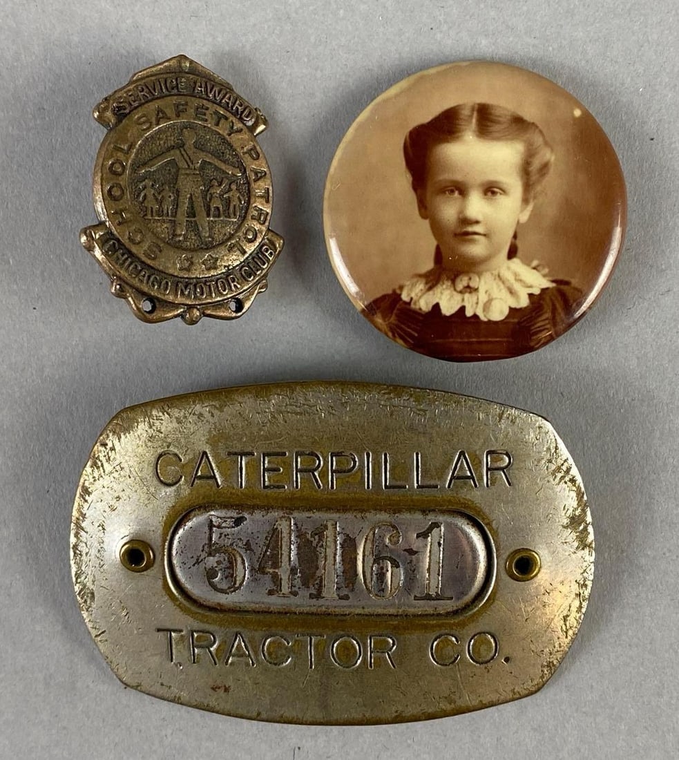 Group of 3 Pins: Includes Chicago Motor Club Safety Award, Caterpillar Tractor Co. employee badge, and portrait button, Largest measures 1 1/2 x 2 1/4 inches.