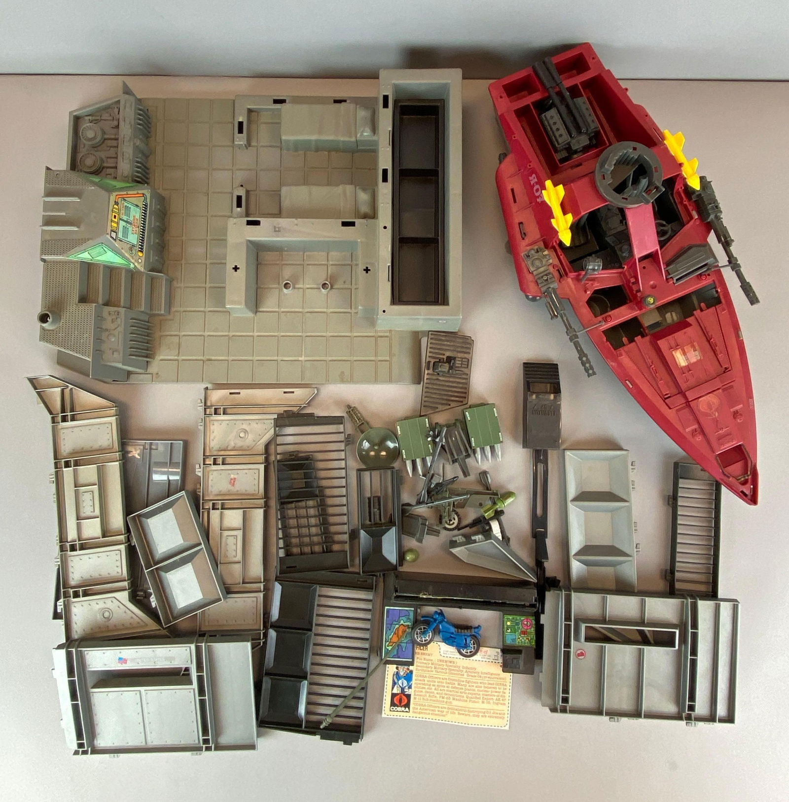 Group of Hasbro GI Joe Cobra Boat and Buildings: Includes various parts to buildings, weapons, cobra officer file card and more, boat measures 20 x 10 x 6 1/2 inches