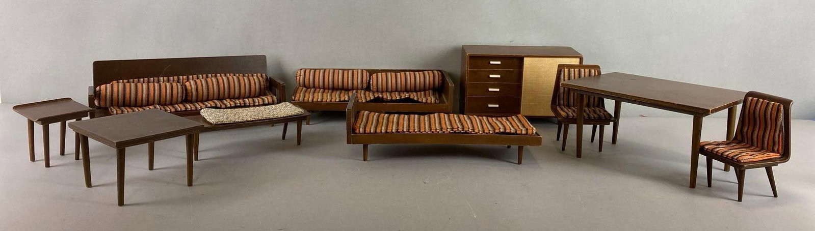 Group of Vintage Mid Century Modern Mattel Doll Wood Furniture: Includes Table, Couch, Chairs and More. Coffee table leg has come off. Largest item measures 4 x 7 1/2 x 5 1/2 inches.