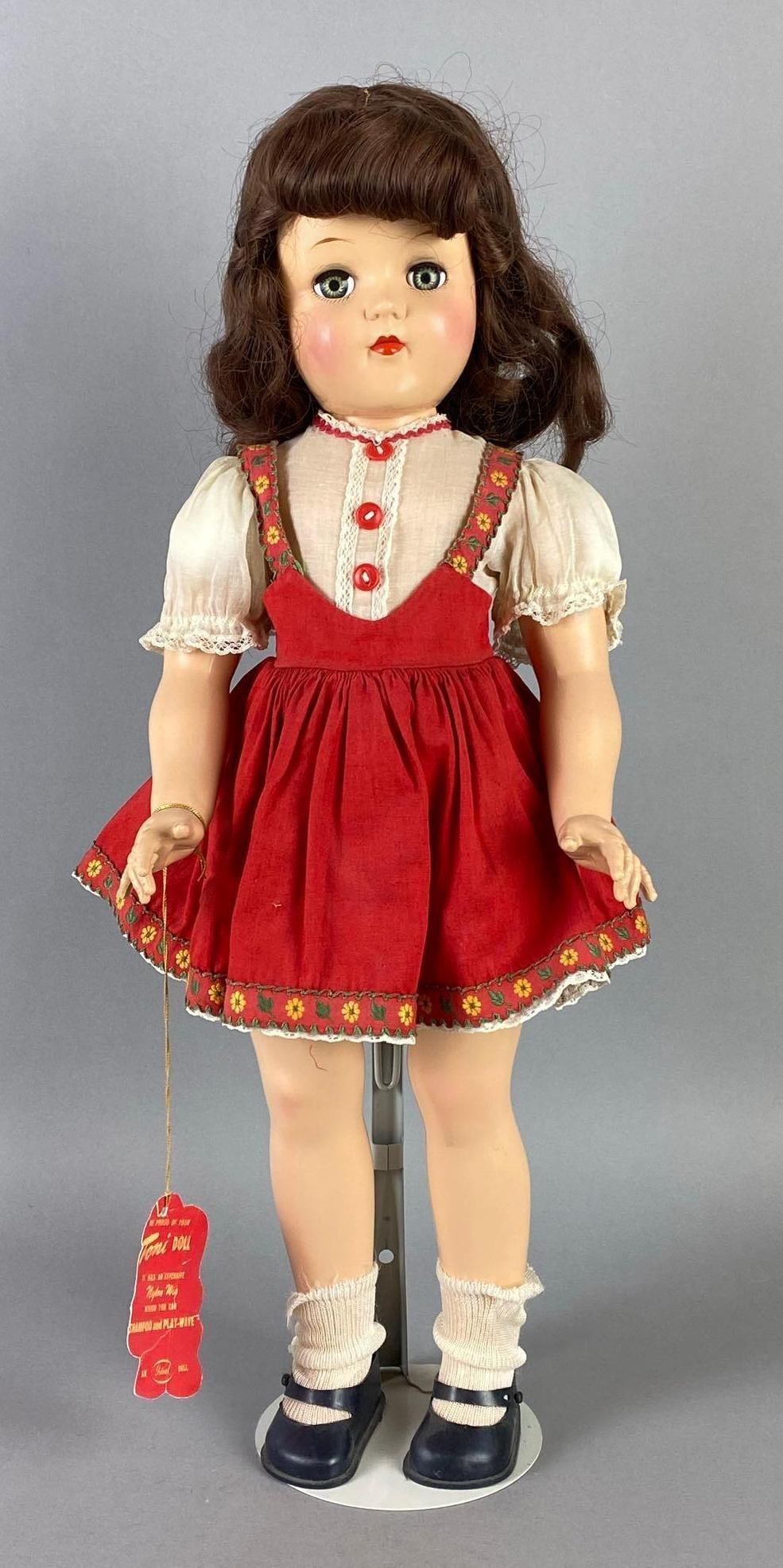 Vintage Ideal Toni P-93 Brunette Doll: Green sleepy eyes, With reproduction tag, Doll stand includes, Doll measures 20 1/2 inches tall.