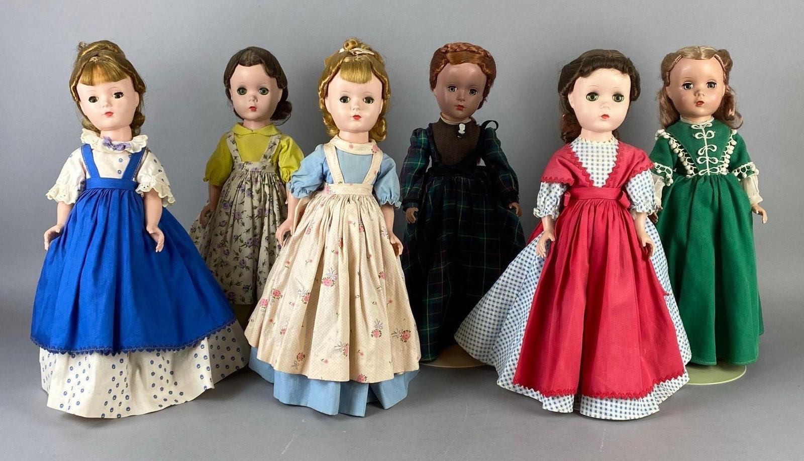 Group of Vintage Madame Alexander Little Women Dolls and More: Includes Beth, Meg, Jo, Amy, and more, Doll stands includes, Green sleepy eyes, Dolls measure 14 1/4 inches tall.