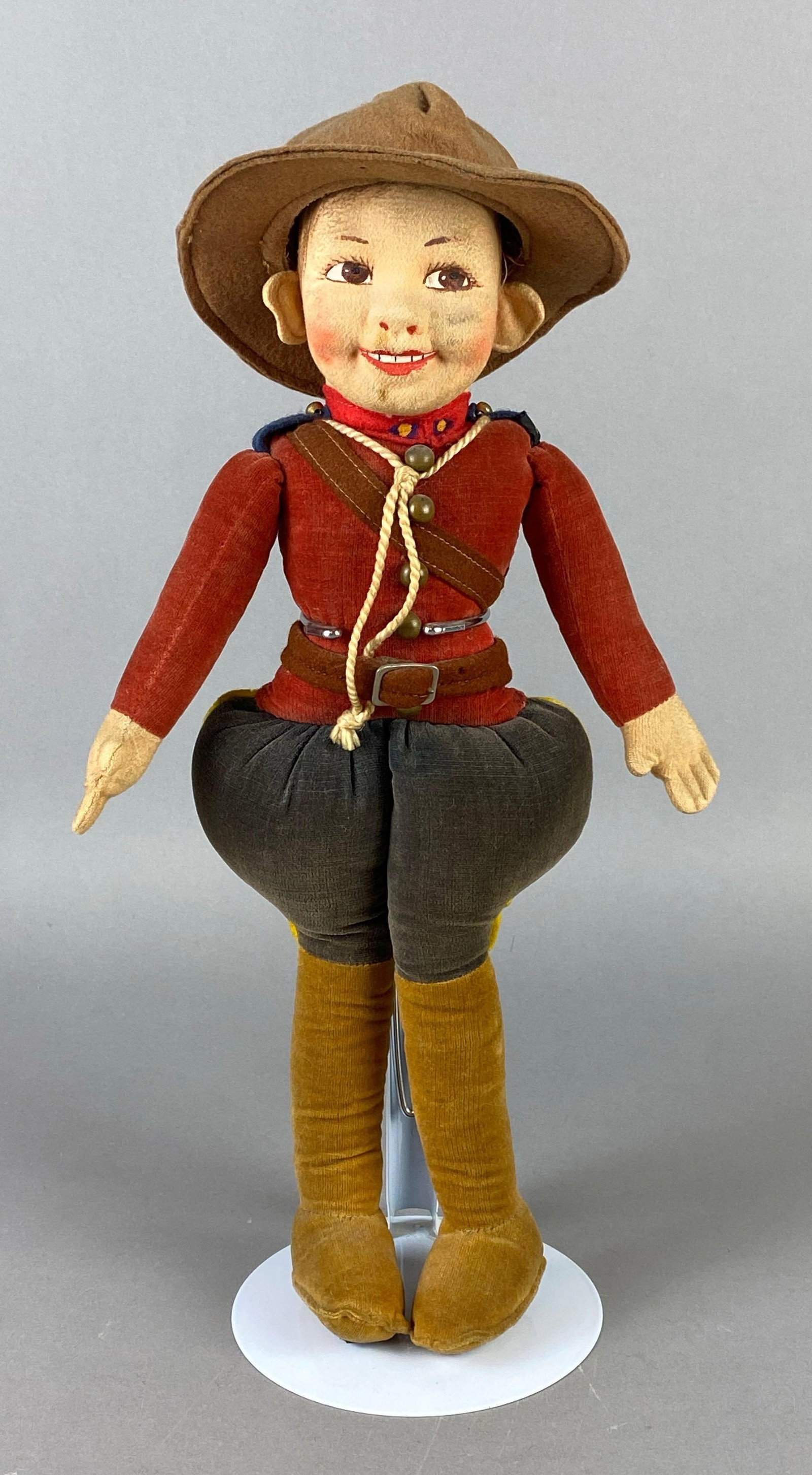 Norah Wellings Royal Canadian Mounted Police Doll: Made in England, Cloth doll, Hand-painted face, Small tear on back of one leg, Doll stand not included, Doll measures 14 inches tall.