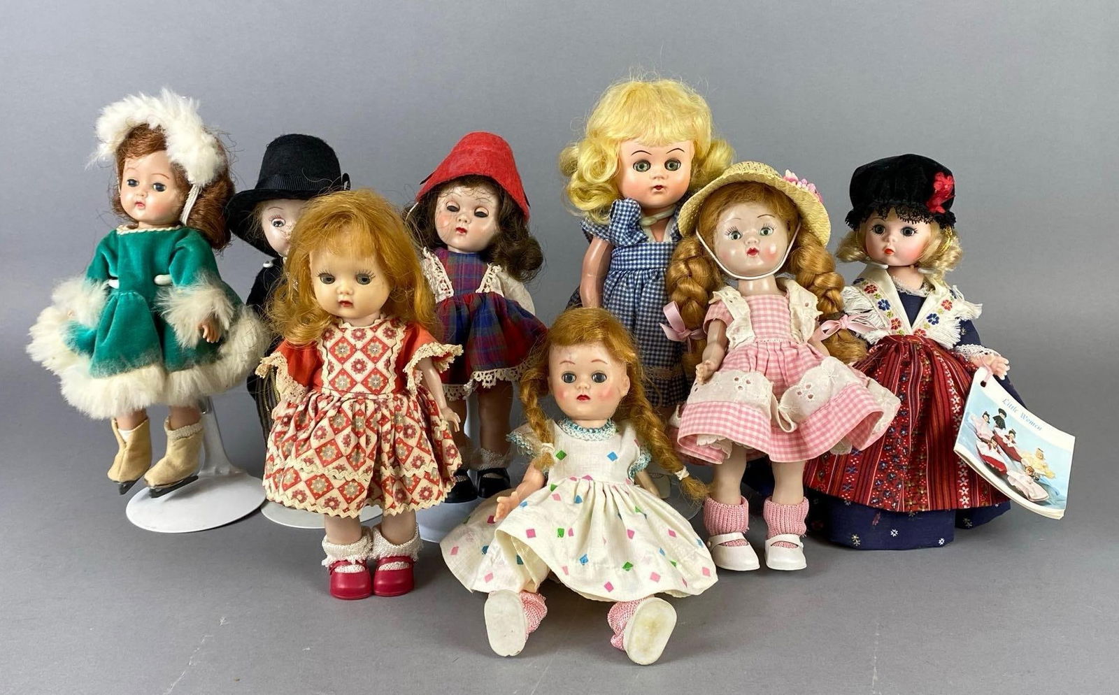 Group of 8 Plastic Sleepy Eye Dolls: Includes Madame Alexander, Nancy Ann Story Book, Vogue Ginny, and more, Some with doll stands, Tallest doll measures 9 inches tall.