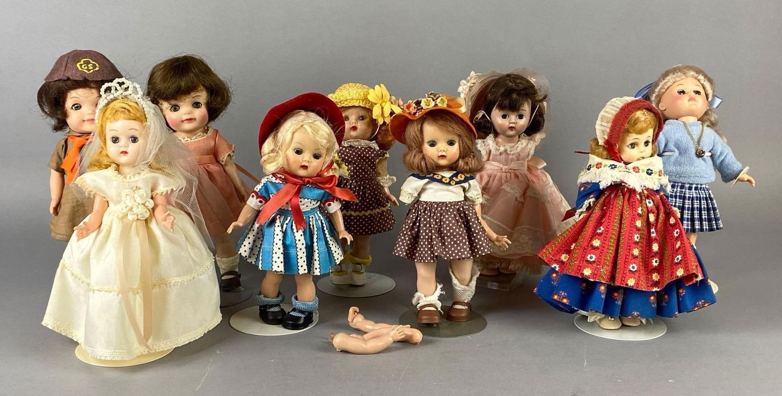 Group of 9 Plastic and Binyl Sleepy Eye Dolls: Includes Effabbee, Nancy Ann Storybook, Madame Alexander, and more, Some missing or broken arms, One head not attached, Doll stands includes, Tallest doll measures 8 1/4 inches tall.