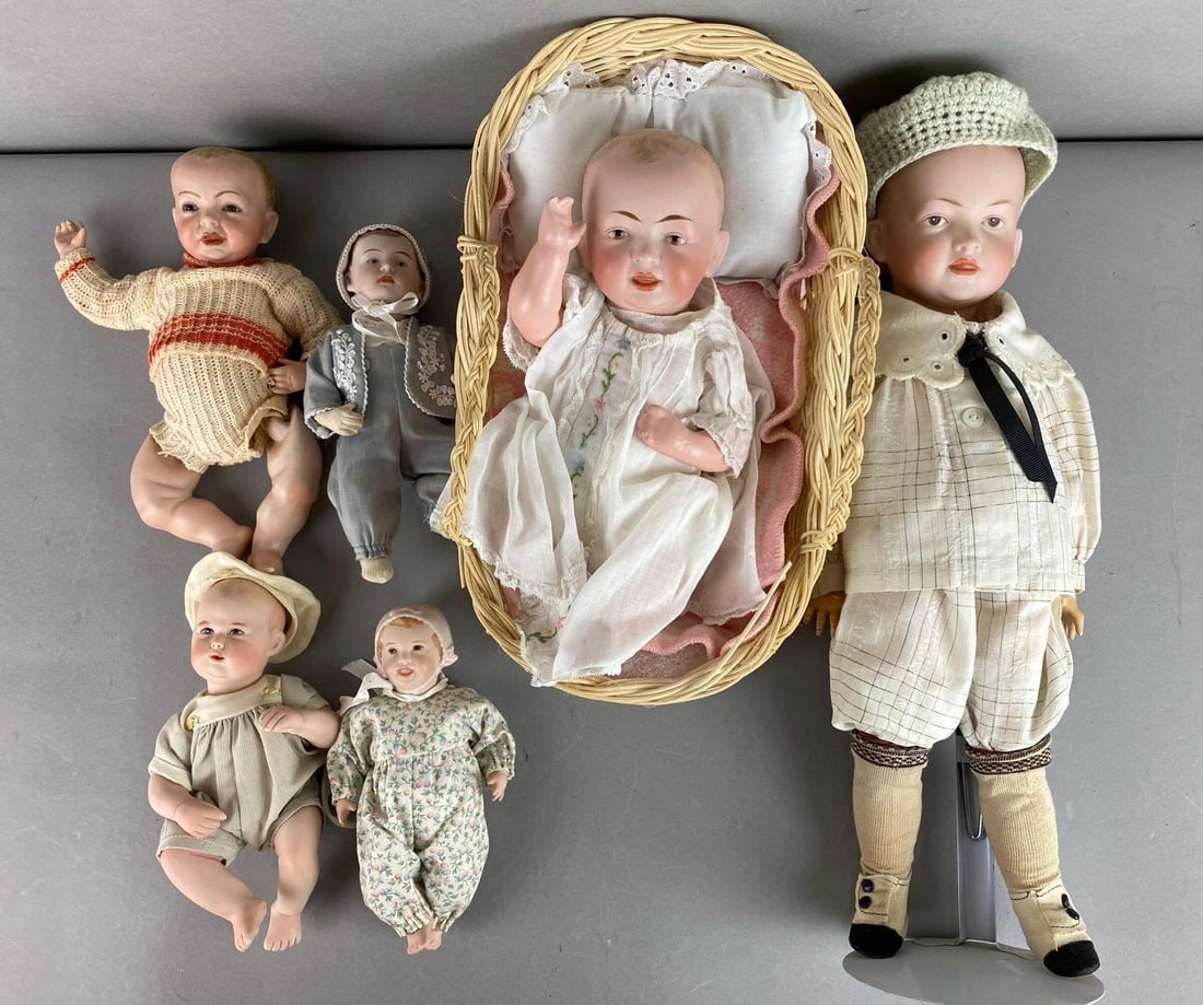 Group of 6 Vintage Porcelain Dolls: Wear consistent with age. Includes one stand. Largest measures 16 inches tall.
