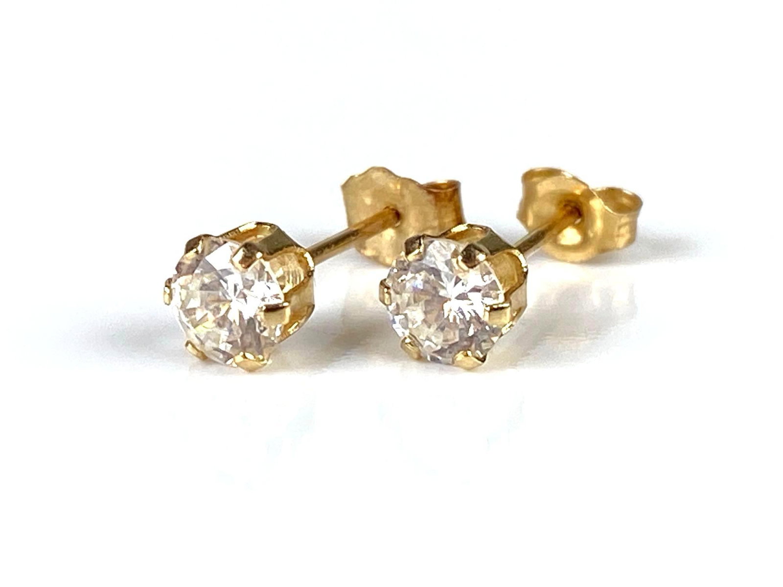 Pair of 14K Gold CZ Stud Earrings: Total weight 0.5g, Both measure 1/4 inch long.