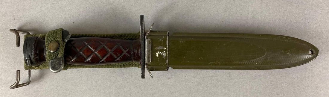 US Army Imperial Bayonet and Scabbard: Wood handle has a chip. Scabbard is marked US M8AI. Bayonet marked Imperial but is worn off. Some chips in blade. Bayonet measures 11 1/2 inches long. Blade measures 6 1/2 inches.