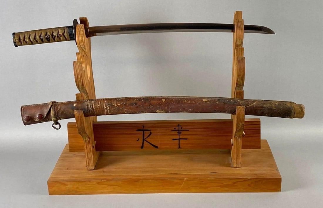 Antique Signed Japanese Katana with Leather Sheath: Brought back by Sgt. Harry Snyder, Colorado 158th RCT, Sharkskin hilt, Cloth wrapped hilt, Sword measures 26 inches long, Blade measures 19 1/4 inch long.