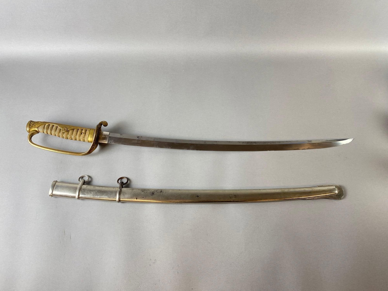 WW2 Era Japanese Officers Sword with Metal Scabbard: Sharkskin hilt, Floral accent guard, Sword measures 33 inches long, Blade measures 25 1/2 inches long.
