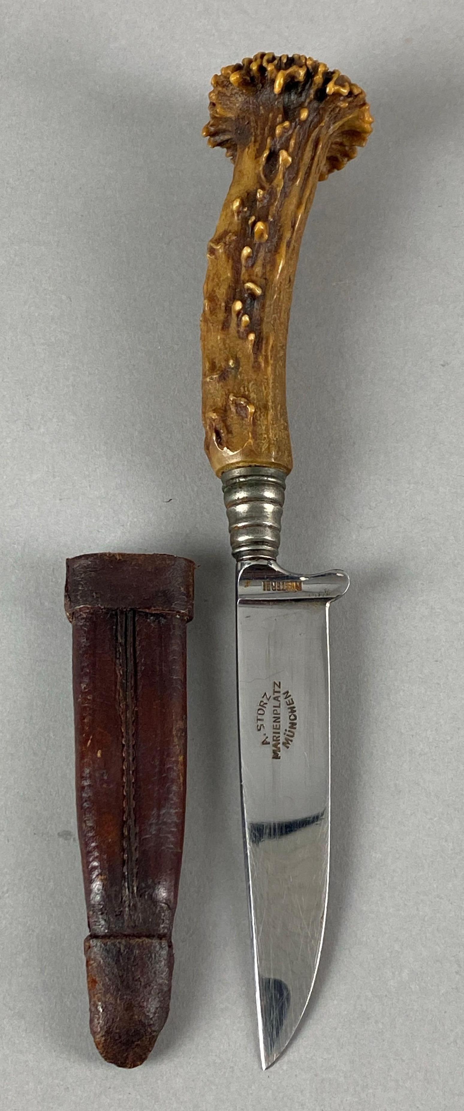 A Storz Marienplatz Munchen Rostfrei Knife with Sheath: Features a stag handle, Measures 8 1/4 inches in length with a 3 1/2 inch blade