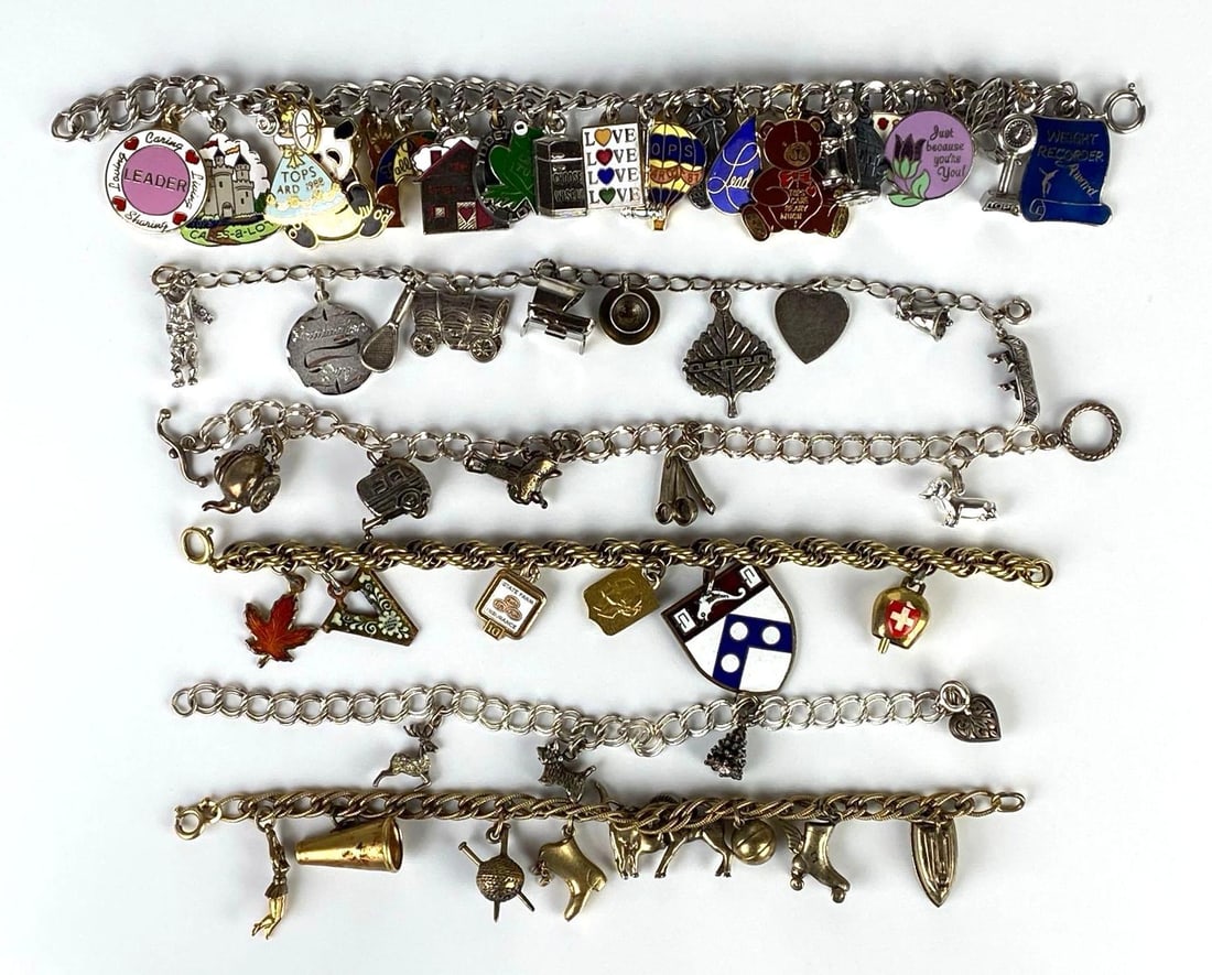 Group of 6 Charm Bracelets: Some sterling charms throughout, Includes horse, castle, tennis racket, butterfly, and more, Longest bracelet measures 8 inches long.