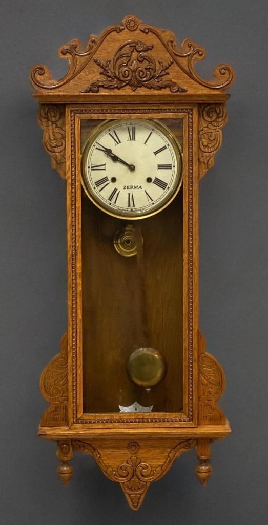 Antique Waterbury Zerma Oak Wall Clock: worked in tests, includes key, measures 40 x 16 x 5 1/4 inches
