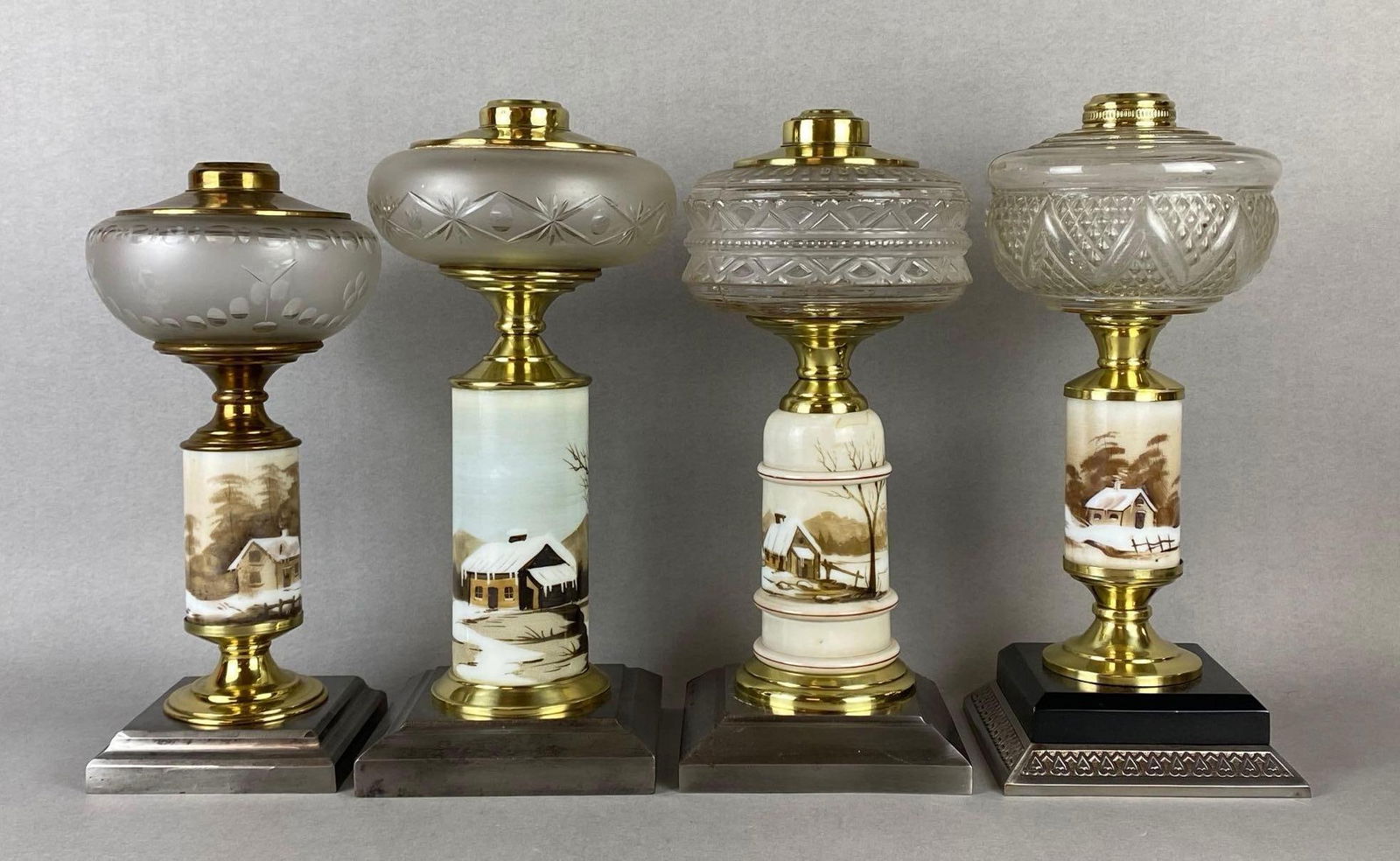 Group of 4 Winter Cabin Painted Milk Glass Oil Lamp Bases: All with etched or embossed clear glass founts, Tallest measures 13 1/2 x 5 1/2 x 5 1/2 inches.