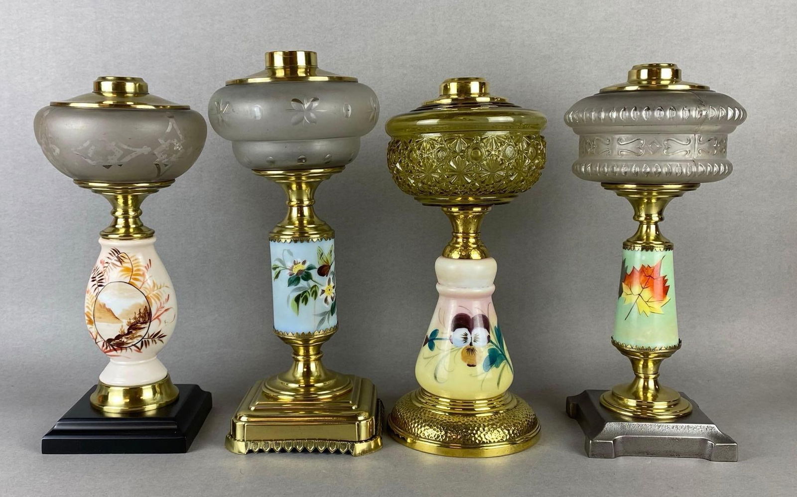 Group of 4 Floral Painted Glass Oil Lamp Bases: Includes 3 with clear glass founts and 1 with yellow glass, Tallest measures 13 1/2 x 5 3/4 x 5 3/4 inches.