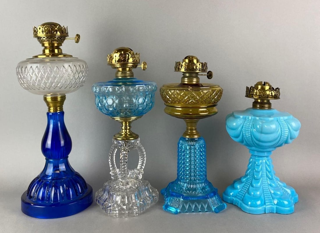 Group of 4 Antique Victorian Pressed Blue Glass Oil Lamps: Includes Coolidge Drape, cathedral, aladdin drape styles and more. Largest measures 17 1/2 x 6 1/2 x 6 1/2 inches.