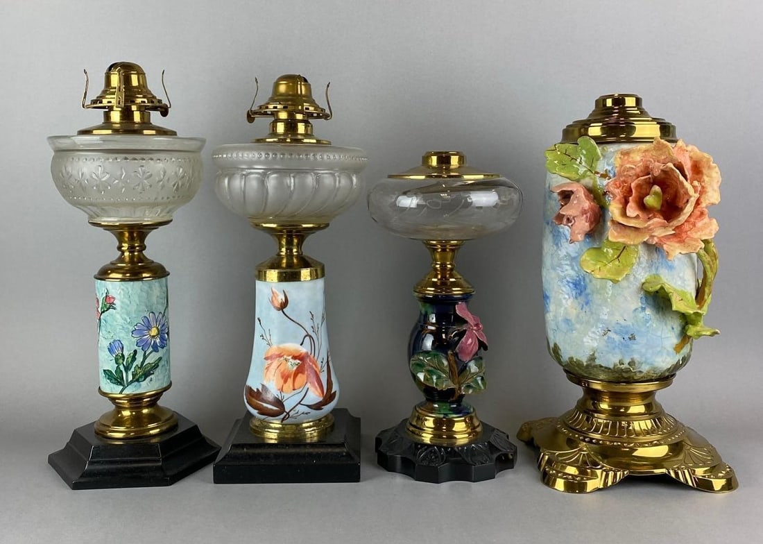 Group of 4 Assorted Antique Victorian Floral Motif Oil Lamps: Includes 2 floral pottery lamps and 2 hand painted floral motif oil lamps. 2 have crazing. Largest measures 14 1/2 x 7 1/2 x 5 1/2 inches.